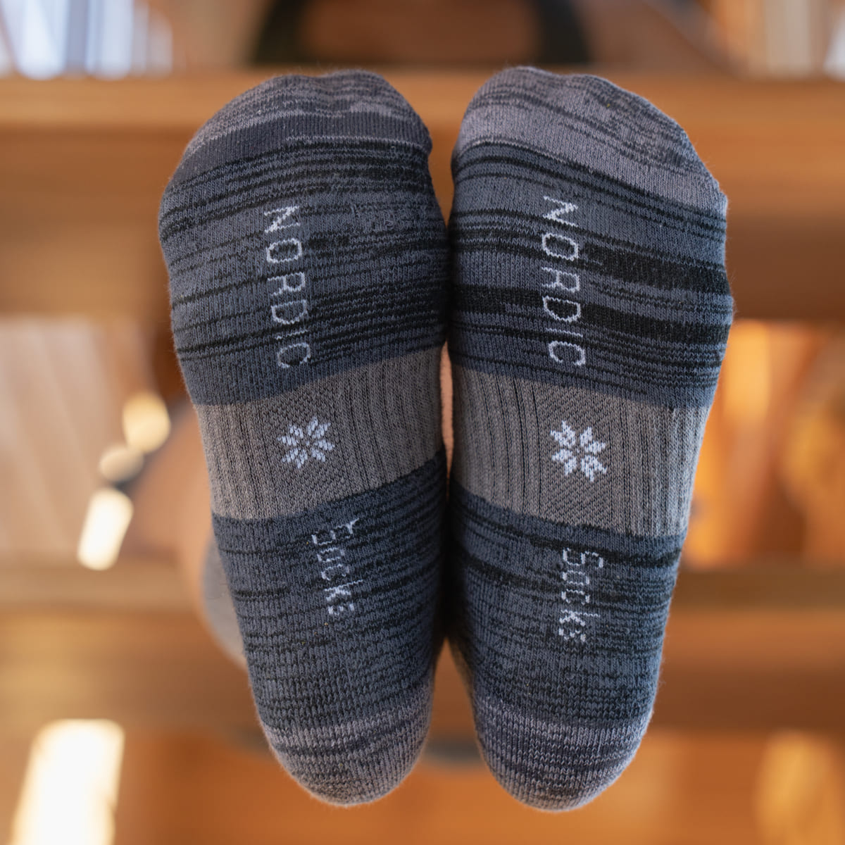 Pair of gray socks with 'Nordic' branding on a blurred background - Nordic Socks